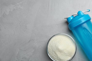 Şişe, protein tozu ve gri arka plan, üstten görünüm üzerinde metin için yer. Shake hazırlık