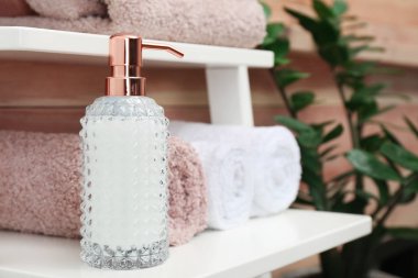 Havlu ve sabun dispenseri banyoda rafta. Metin için yer