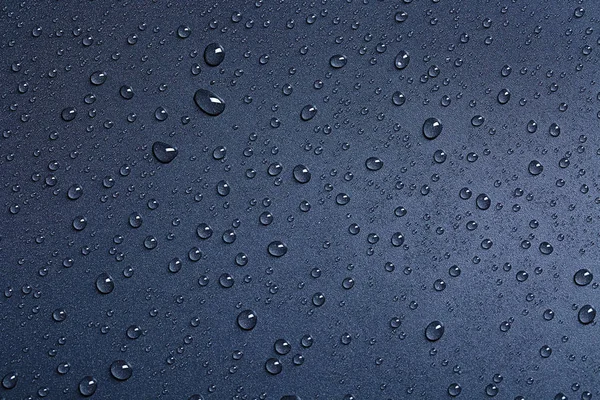 Water drops on black background, top view