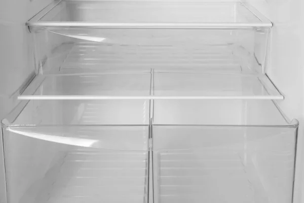 Modern open refrigerator with empty shelves, closeup