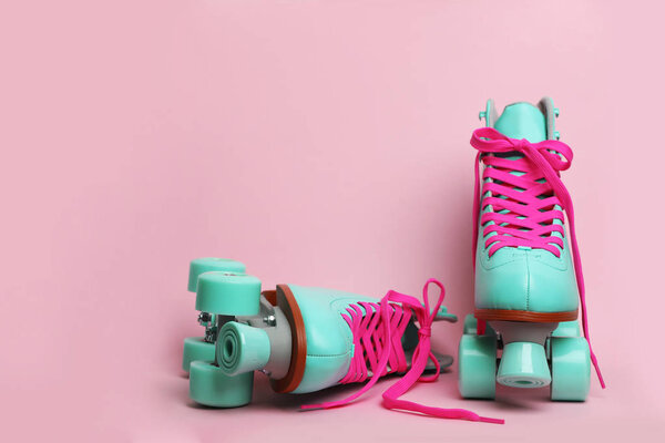 Pair of stylish quad roller skates on color background. Space for text