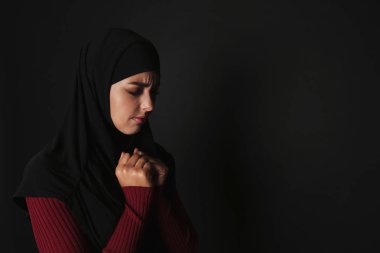 Koyu arka plan üzerinde dua hijab üzgün Müslüman kadın portresi. Metin için yer