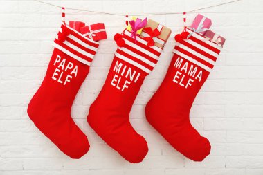 Kırmızı Noel çorap tuğla duvara asılı hediye dolu. İç dekor için fikir