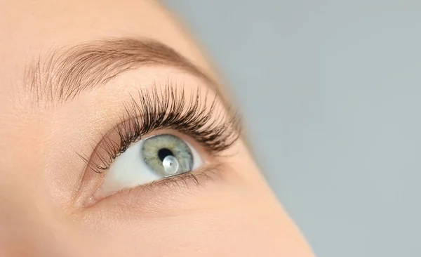 Junge Frau Mit Schönen Langen Wimpern Auf Grauem Hintergrund Nahaufnahme — Stockfoto