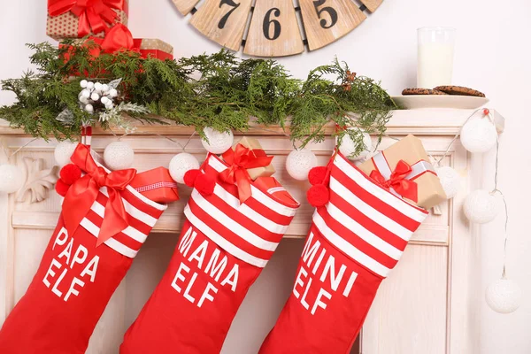 红色圣诞长袜挂在装饰的壁炉上 节日内部 — 图库照片