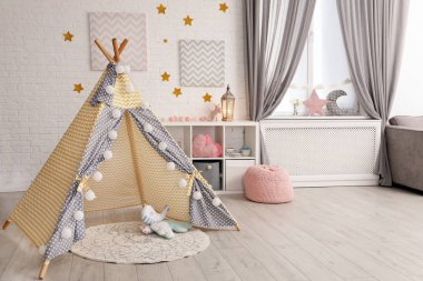Oyun çadırı ve oyuncaklarla dolu rahat çocuk odası
