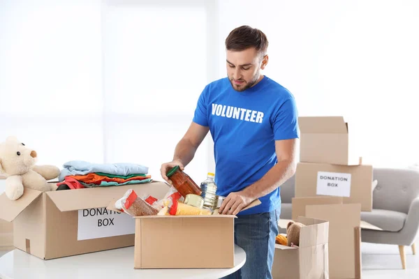 Hombre Voluntario Recogiendo Donaciones Mesa Interior — Foto de Stock