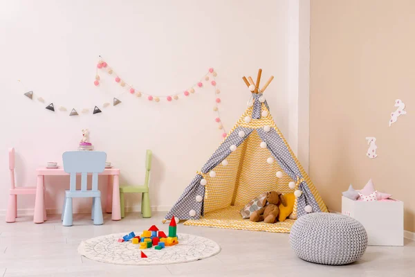 Cozy child room interior with play tent, table and modern decor elements