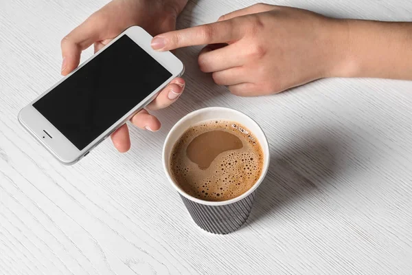 Žena Používající Mobilní Telefon Stolu Lepenkové Šálek Aromatické Kávy — Stock fotografie