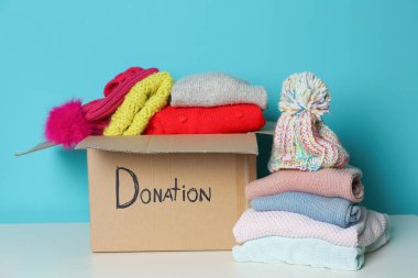 Bağış kutusu ve renk arka plan karşı masada örme giyim