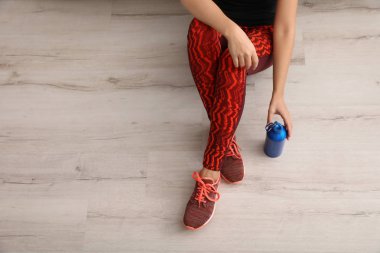 Şişe suyu kapalı, üstten görünüm yere oturmak ile spor giyim kadın. Metin için yer