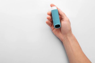 Beyaz arka plan üzerinde üstten görünüm astım inhaler tutan adam