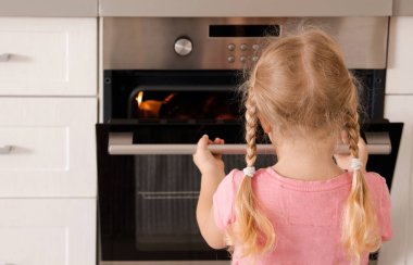 Küçük kız açılış fırın mutfak pişirme sırasında