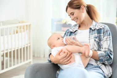 Ona bebek içki odasında şişe veren güzel annesi. Metin için yer