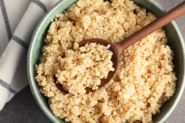 Pişmiş quinoa kase ve tahta kaşık masada, portre