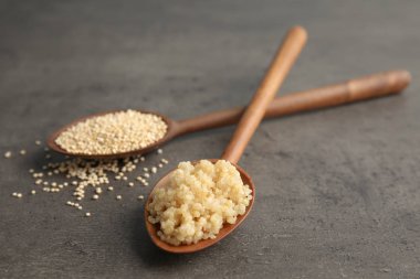 Çiğ ve pişmiş quinoa masada kaşıklarla