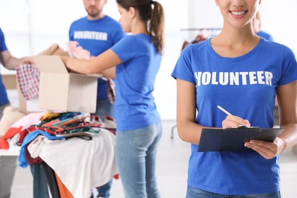 Mujer Voluntaria Con Portapapeles Listando Donaciones Interiores —  Fotos de Stock