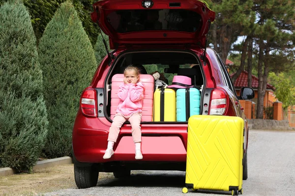 Симпатична Маленька Дівчинка Сидить Багажнику Автомобіля Завантаженому Валізами Відкритому Повітрі — стокове фото