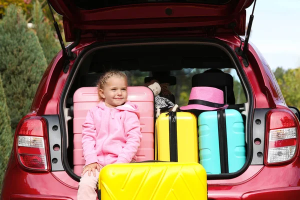 Cute Little Girl Sitting Car Trunk Loaded Suitcases Outdoors — Stock Photo, Image