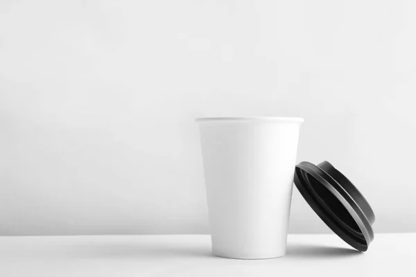 Takeaway paper coffee cup and lid on white background. Space for design