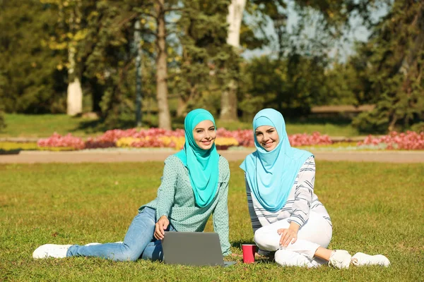 Мусульманские Женщины Хиджабах Ноутбуком Сидят Зеленой Лужайке Открытым Небом — стоковое фото
