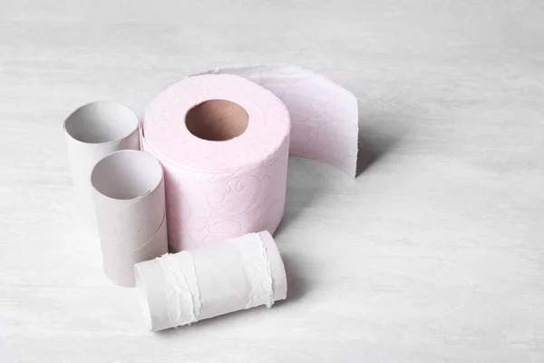 Toilet paper roll and empty tubes on wooden background. Space for text