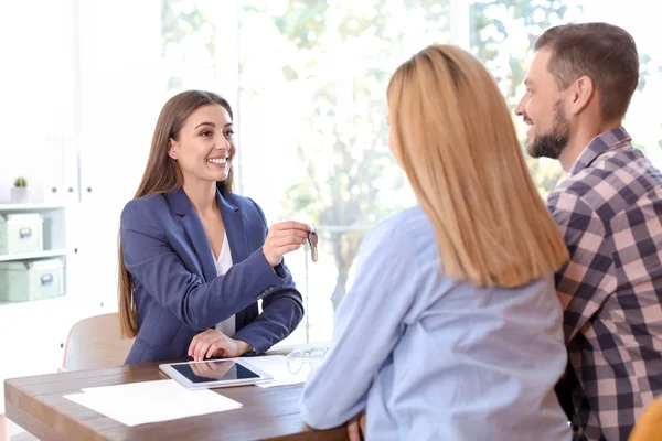 Agente Imobiliário Feminino Dando Chave Casa Para Casal Mesa Escritório — Fotografia de Stock