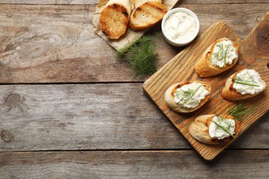 Ahşap masa, düz üstünde lezzetli krem peynirli ekmek yatıyordu. Metin için yer