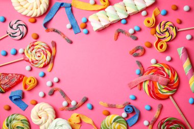 Farklı lezzetli şekerlerle düz konum ve renk arkaplanı üzerine metin için boşluk