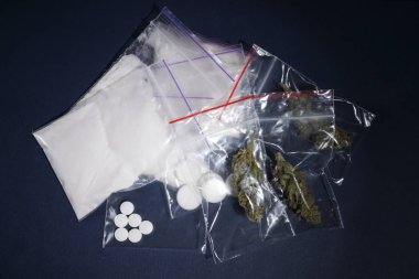 Kokain, kurutulmuş kenevir ve ecstasy koyu arka planda, üstten görünüm