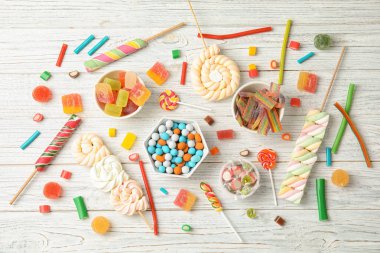 Birçok farklı lezzetli şeker beyaz ahşap arka planda, üstten görünüm