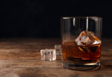 Masada buz küpleri ile cam altın viski. Metin için yer