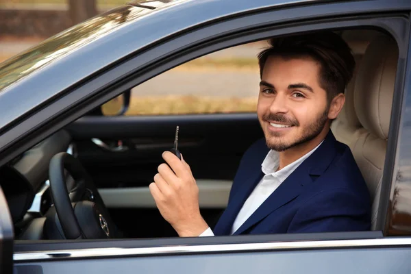 若い男が自動で車のキーを保持しています 運転免許試験 — ストック写真