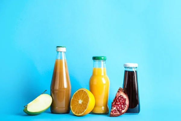 別のジュース 色背景の上に新鮮な果物と瓶 — ストック写真