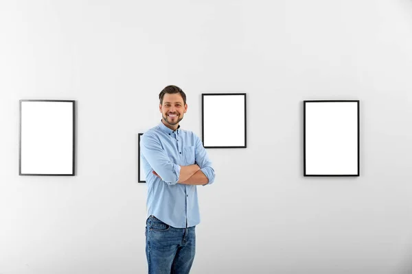 Man near wall with exposition in modern art gallery
