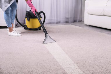 Kadın ile elektrikli süpürge odasında halı kir kaldırma