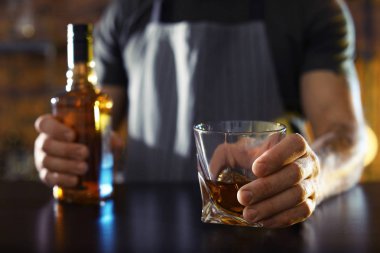 Barmen ile cam ve şişe viski bar, closeup içinde kasaya. Metin için yer