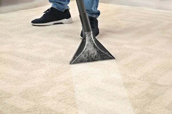 クローズ アップの部屋で掃除機をカーペットから汚れを除去する男 — ストック写真