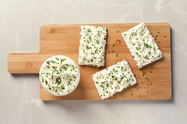 Tasty snack with cream cheese on gray table, flat lay