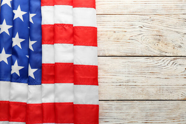 American flag on white wooden background, top view with space for text