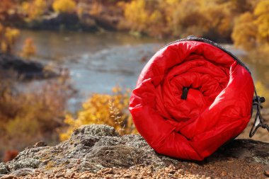 Rock açık havada, metin için yer üzerinde kırmızı uyku tulumu. Kamp ekipmanları