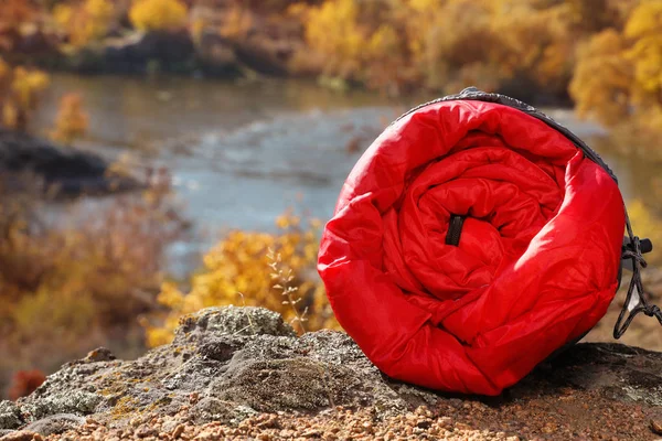 岩屋外 テキスト用のスペースに赤い寝袋 キャンプ用品 — ストック写真
