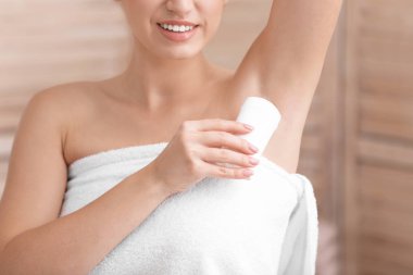 Güzel genç kadın banyoda duş sonra deodorant uygulamak