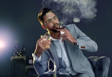 Bardak viski ve puro kapalı masada oturan adam