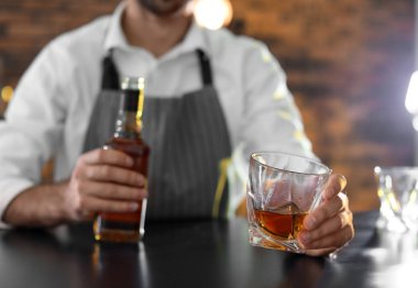 Barmen ile cam ve şişe viski bar, closeup içinde kasaya. Metin için yer