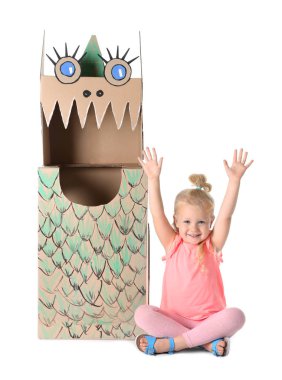 Cute little girl playing with cardboard dragon on white background clipart