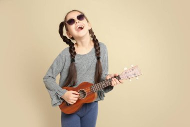 Renk arka plan üzerinde gitar çalmak küçük neşeli kız portresi