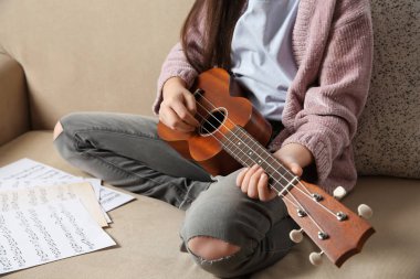 Küçük kızı kanepeye, closeup gitar çalmak