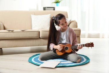 Sevimli küçük kız oda katta gitar çalmak