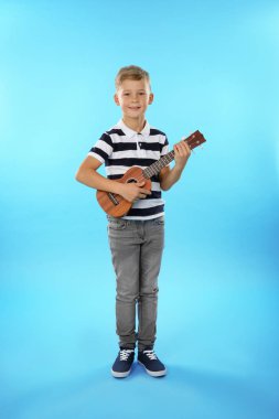 Küçük çocuk renk arka plan üzerinde gitar çalmak